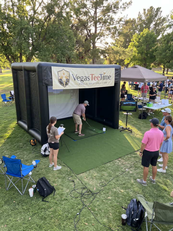 Guests lining up for a closest-to-the-pin challenge at the Vegas Tee Time mobile golf simulator during a charity fundraiser in a park